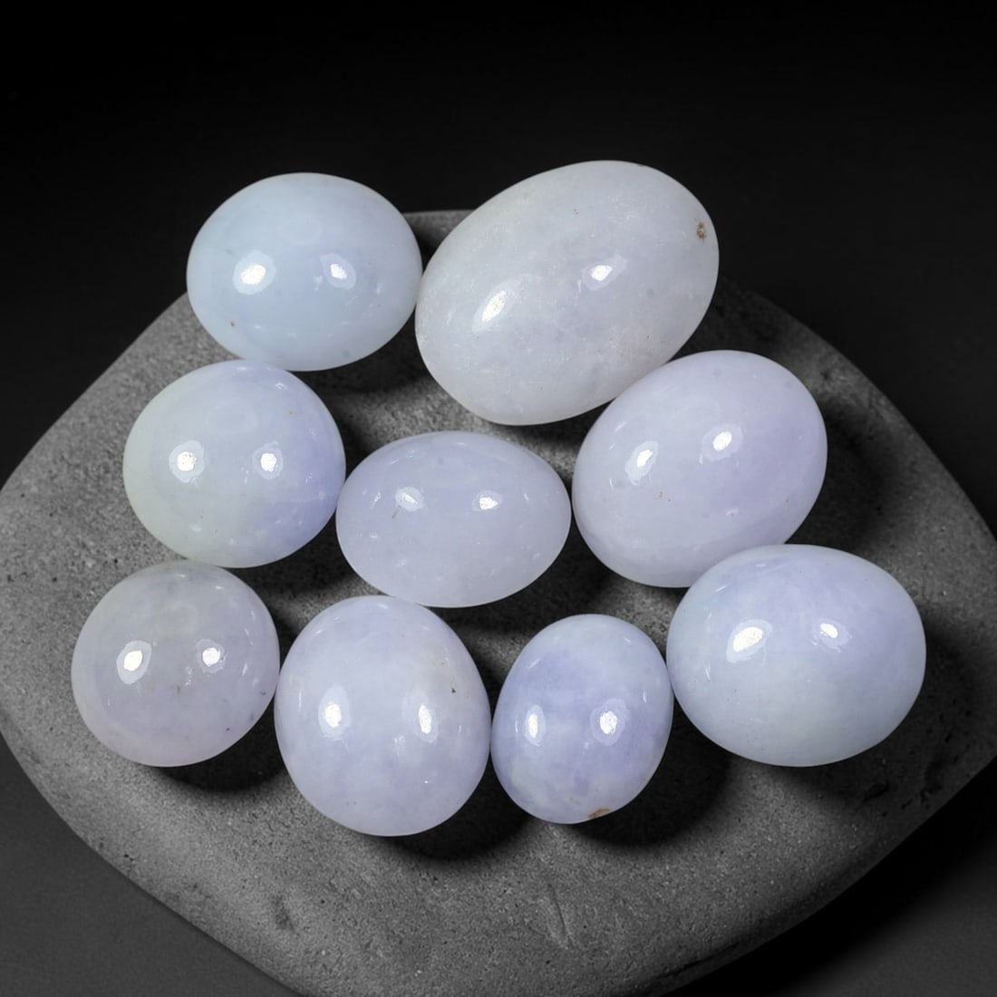 75.60ct Natural Burmese Type A Lavender Jadeite Jade Cabochon Parcel Lot, 34EX: This polished cabochon parcel features oval and round cabochon Type A jadeite jade displaying soft lavender-lilac body tones across the set. Smooth high-gloss domed surfaces showcase gentle colour var