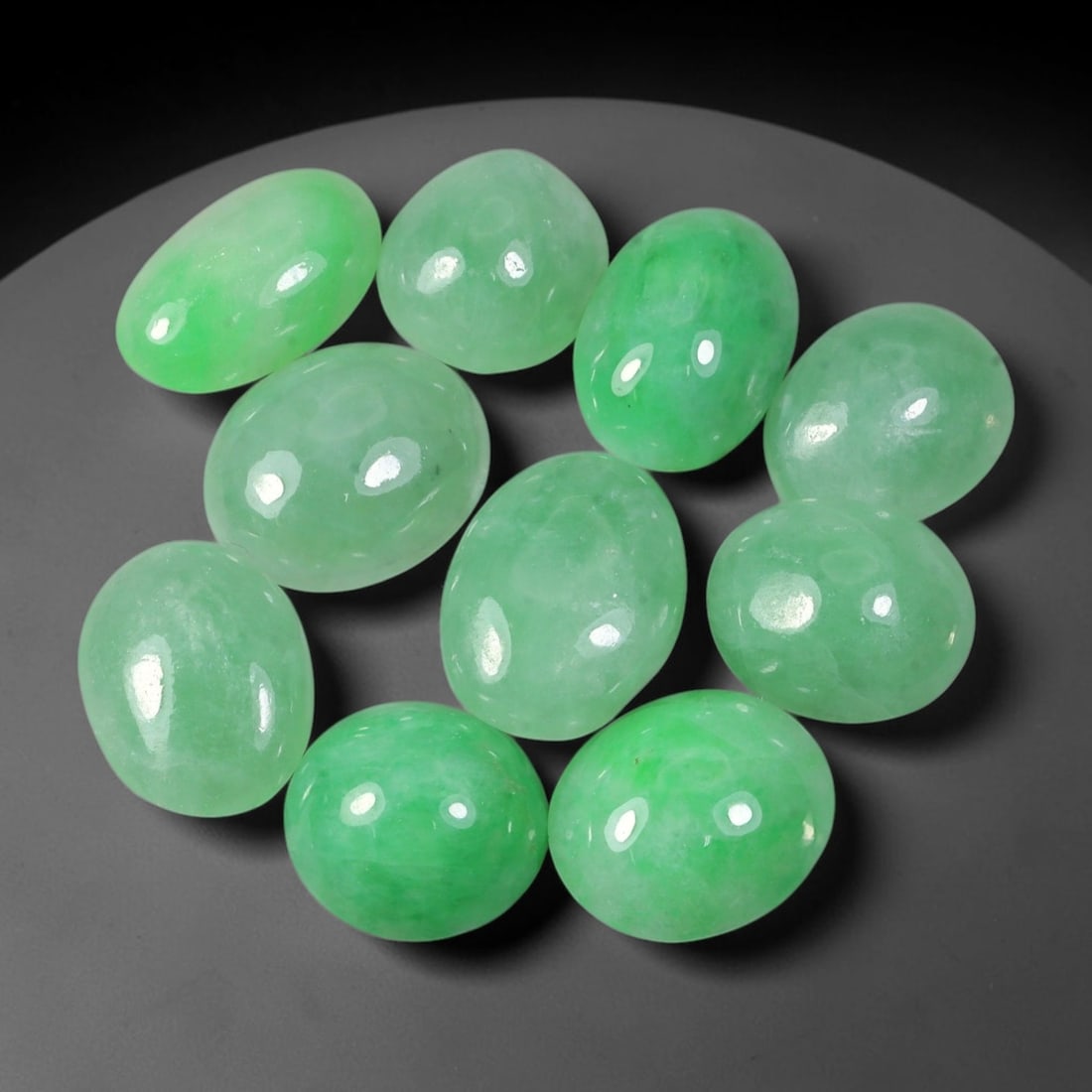 31.56ct Natural Burmese Type A Jadeite Jade Cabochon Parcel Lot, 44EX: This oval cabochon parcel consists of polished Type A jadeite cabochons showing soft pastel to medium lively green colour shades across smooth domed surfaces. Glossy polished finishes reveal natural i