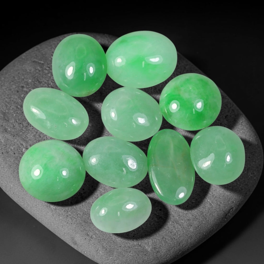 29.00ct Natural Burmese Type A Jadeite Jade Cabochon Parcel Lot, 41EX: This oval cabochon parcel consists of polished Type A jadeite cabochons showing soft pastel to medium lively green colour shades across smooth domed surfaces. Glossy polished finishes reveal natural i