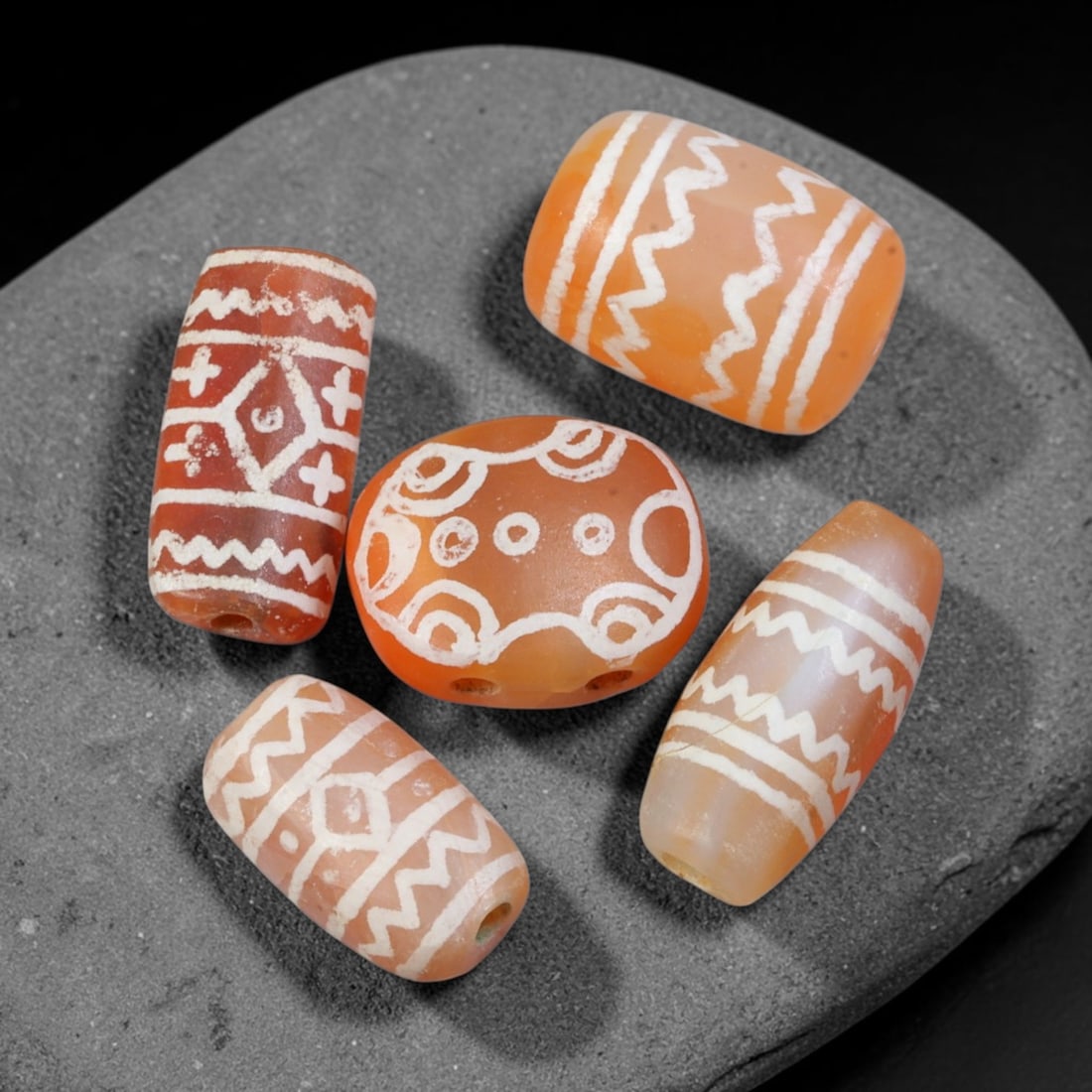 Ancient Sino-Himalayan Region Etched Carnelian Beads Parcel Lot, 4EY: Group of ancient etched carnelian beads originating from the Sino-Himalayan cultural sphere, displaying classic alkali-etch decorative motifs across translucent carnelian bodies. Each bead exhibits hi