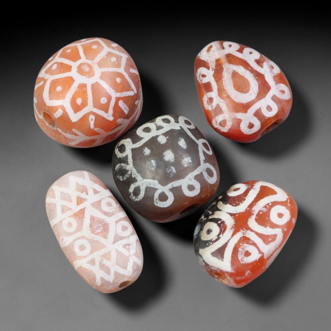 Ancient Sino-Himalayan Region Etched Carnelian Beads Parcel Lot, 12EY: Group of ancient etched carnelian beads originating from the Sino-Himalayan cultural sphere, displaying classic alkali-etch decorative motifs across translucent carnelian bodies. Each bead exhibits hi