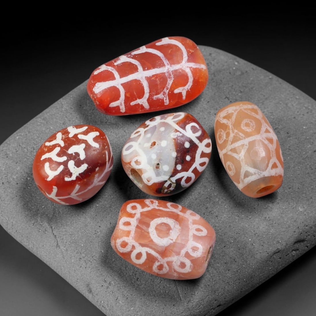 Ancient Sino-Himalayan Region Etched Carnelian Beads Parcel Lot, 11EY: Group of ancient etched carnelian beads originating from the Sino-Himalayan cultural sphere, displaying classic alkali-etch decorative motifs across translucent carnelian bodies. Each bead exhibits hi