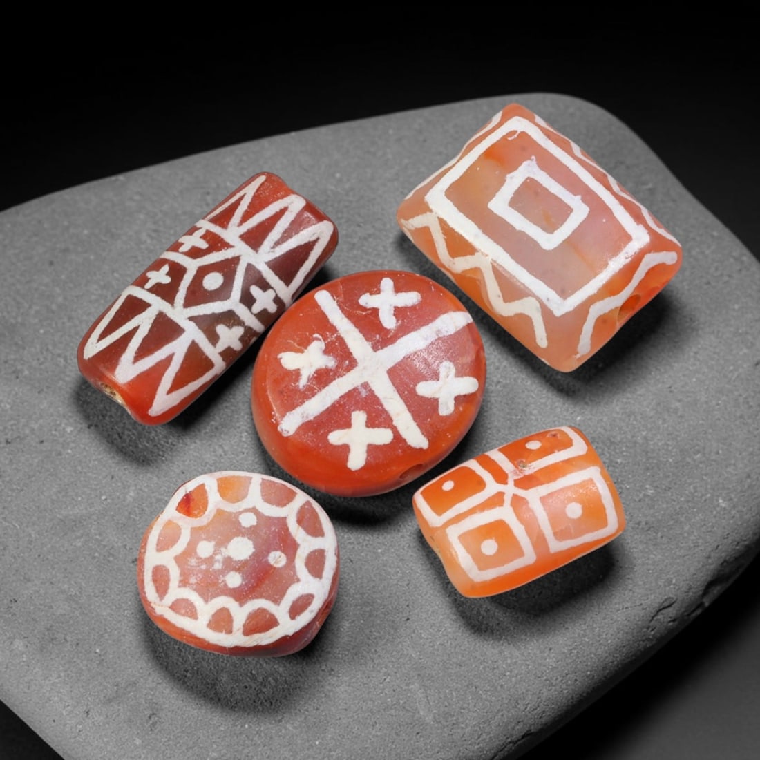 Ancient Sino-Himalayan Region Etched Carnelian Beads Parcel Lot, 10EY: Group of ancient etched carnelian beads originating from the Sino-Himalayan cultural sphere, displaying classic alkali-etch decorative motifs across translucent carnelian bodies. Each bead exhibits hi