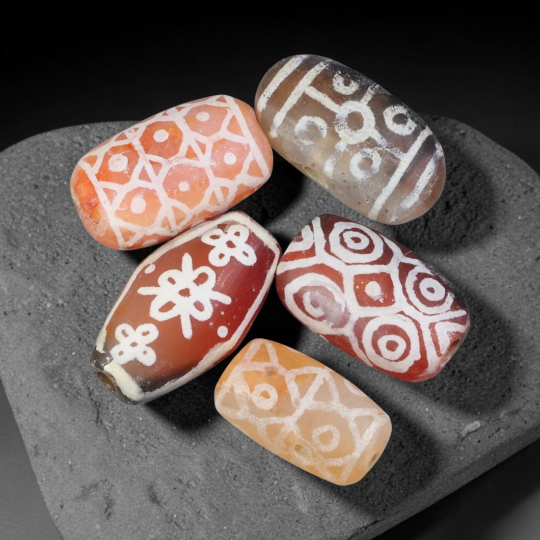 Ancient Sino-Himalayan Region Etched Carnelian Beads Parcel Lot, 3EY: Group of ancient etched carnelian beads originating from the Sino-Himalayan cultural sphere, displaying classic alkali-etch decorative motifs across translucent carnelian bodies. Each bead exhibits hi