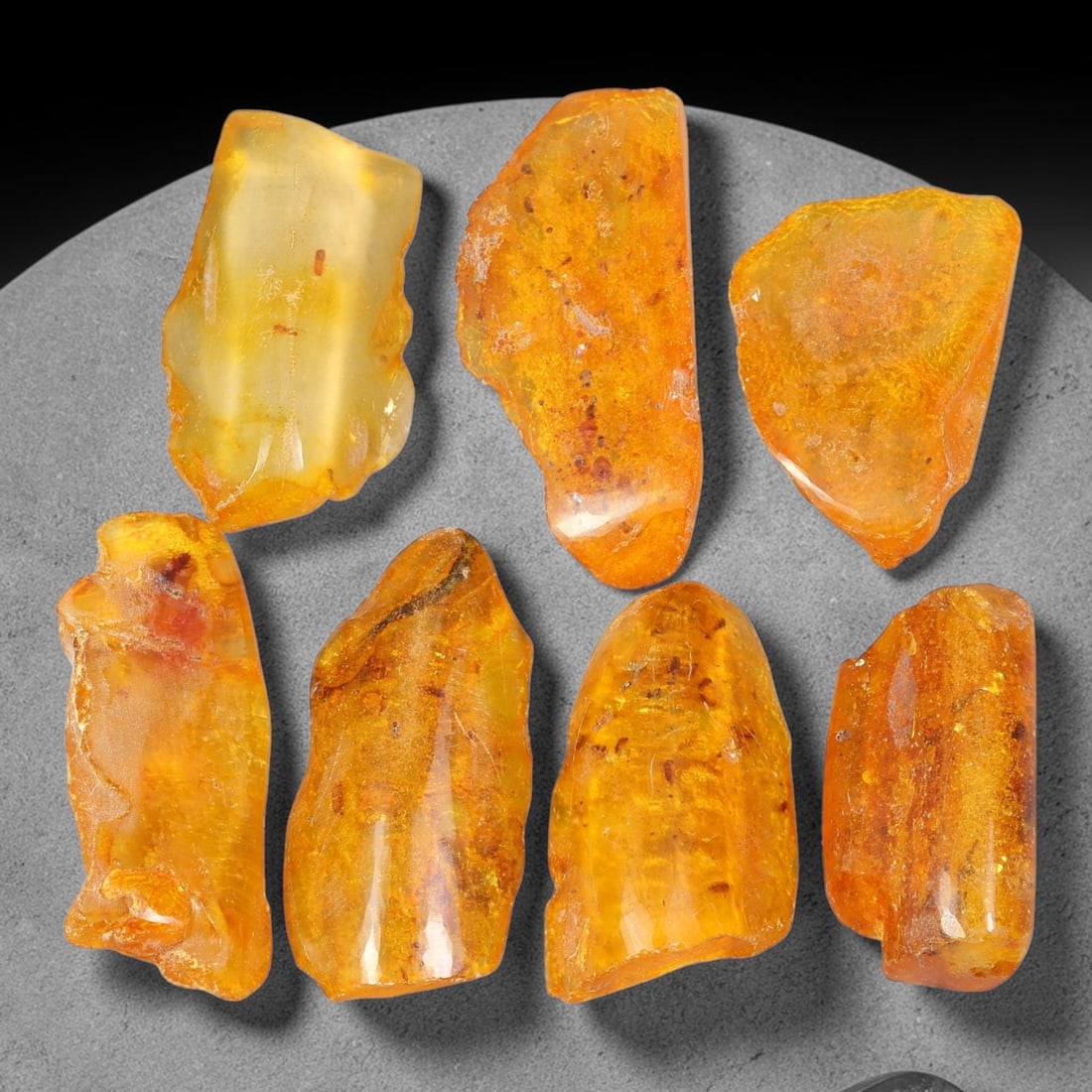 104.91ct Natural Baltic Amber Polished Rough Parcel Lot, 45EY: This polished rough parcel consists of free-form baltic amber specimens with warm golden-yellow to honey-orange translucency. Partial high-gloss polished surfaces reveal visible insect debris and orga