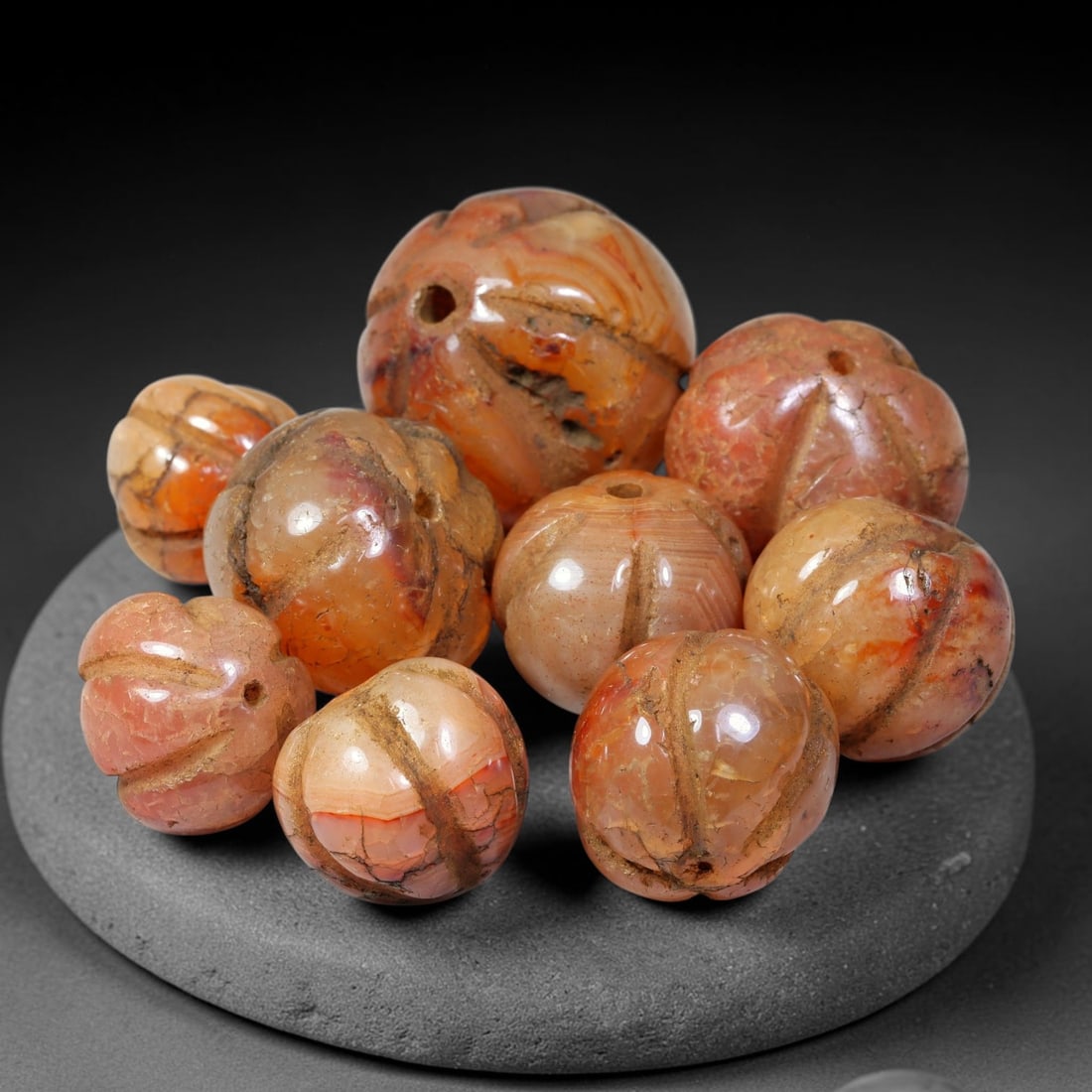 Ancient Medieval Khmer Angkor Carved Carnelian Melon Beads Parcel Lot (802-1431 CE), 42BC: Group of ancient Khmer Angkor period carved natural carnelian melon-form beads, each exhibiting characteristic segmented melon-groove carving, historic drill perforations, deep accumulated surface pat