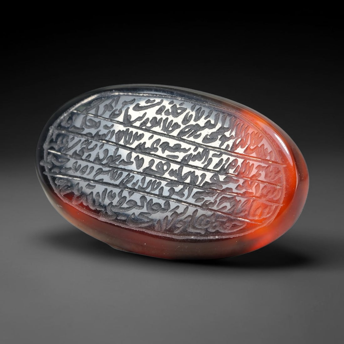 Ancient Medieval Mughal Islamic Carnelian Agate Calligraphic Script Talisman 1526-1857 CE, 7ET: Polished rich-toned carnelian agate cabochon, finely engraved with divided panels of Islamic calligraphic intaglio inscriptions. Deep crisp engraving features segmenting incised lines organizing the s
