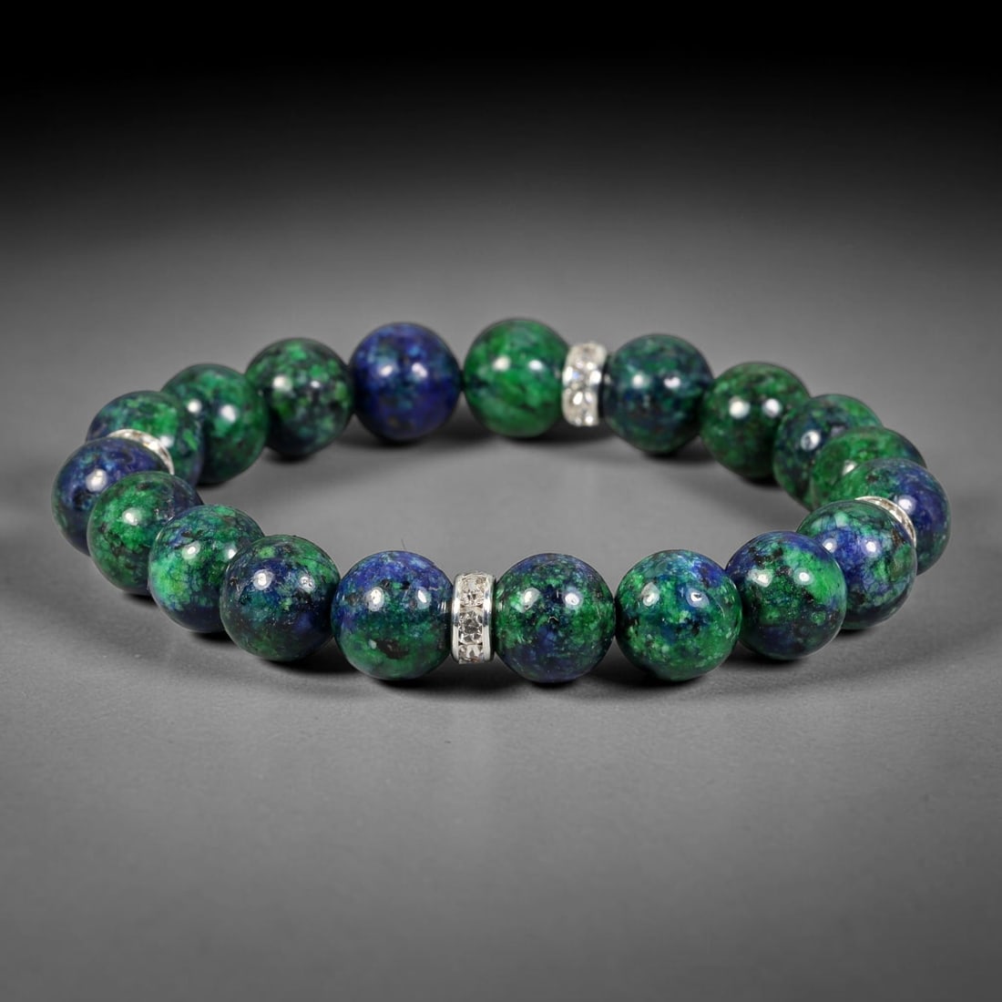 Natural Chrysocolla Beaded Stretch Bracelet with Silver Tone Crystal Spacers, 99FV: Elastic stretch bracelet featuring smooth 10mm natural chrysocolla round beads accented with polished silver-toned crystal spacer beads. Each stone holds unique blended green and blue natural patterni