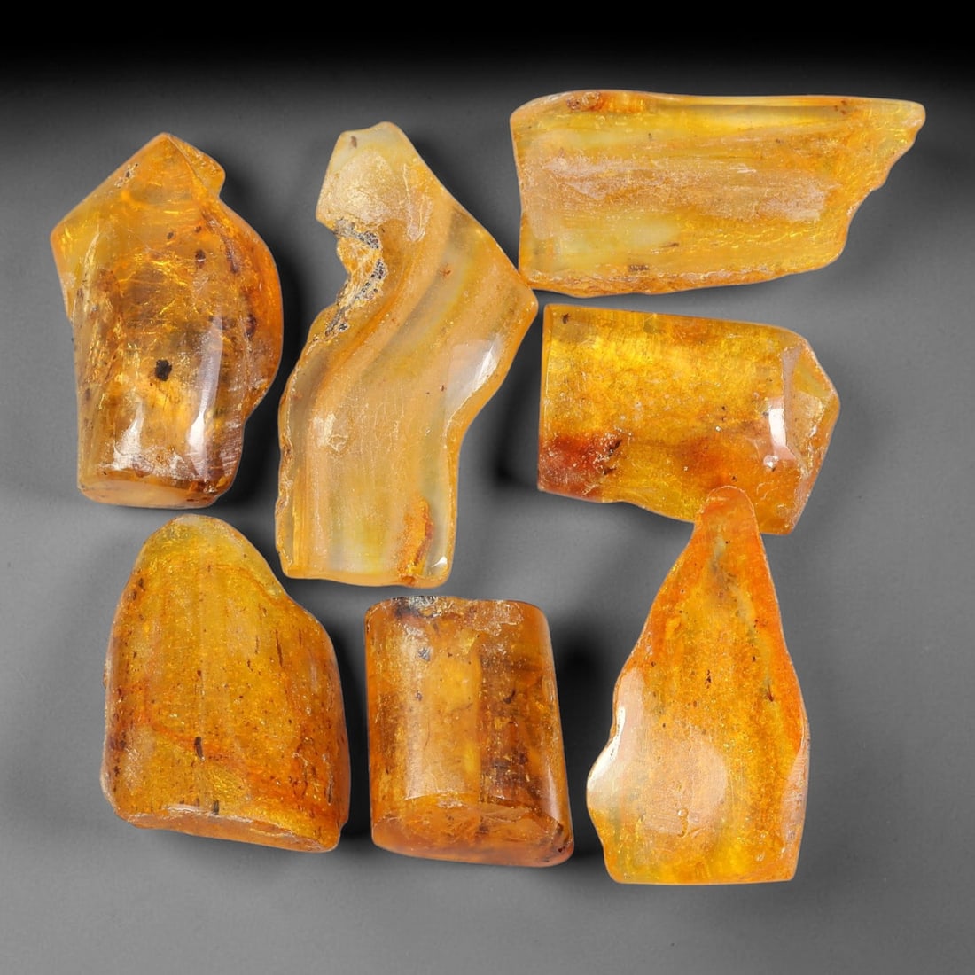 119.86ct Natural Baltic Amber Polished Rough Parcel Lot, 42EY: This polished rough parcel consists of free-form baltic amber specimens with warm golden-yellow to honey-orange translucency. Partial high-gloss polished surfaces reveal visible insect debris and orga