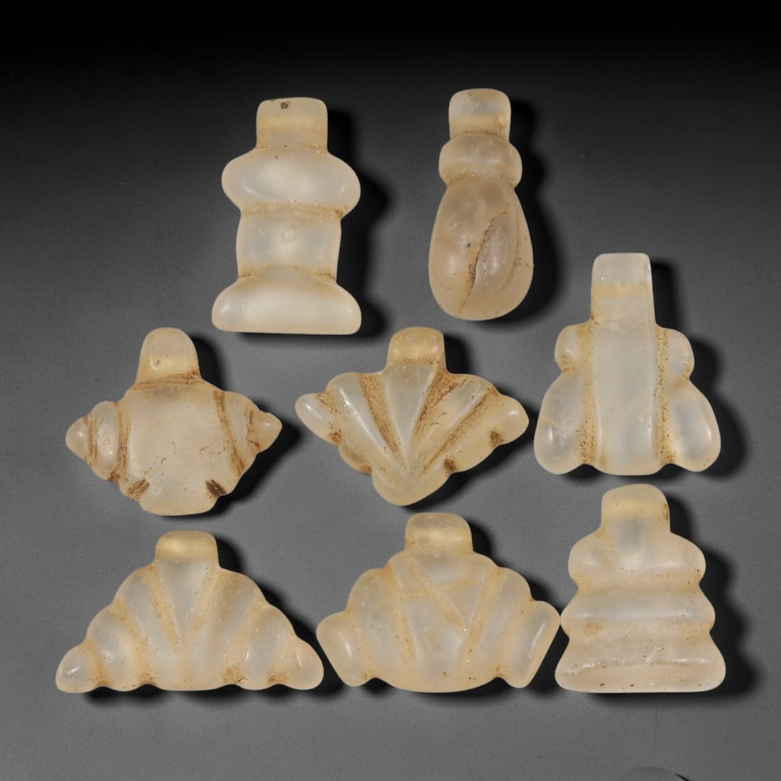 Ancient Medieval Coptic Christian Egyptian Rock Crystal Amulets Parcel Lot, 18EY: Collection of rock-crystal talismans originating from Medieval Coptic Egyptian cultural context, each formed with integral suspension lugs for wear. The group displays carved surface detailing, consis
