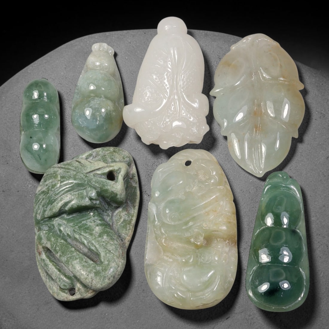 260.94ct Natural Burmese Type A Jadeite Jade Carving Pendant Parcel Lot, 91EX: This parcel lot consists of hand-carved Type A jadeite pendants displaying varied natural colour tones including deep forest green, soft pale green, and warm yellow-gold hues. Each piece finished with