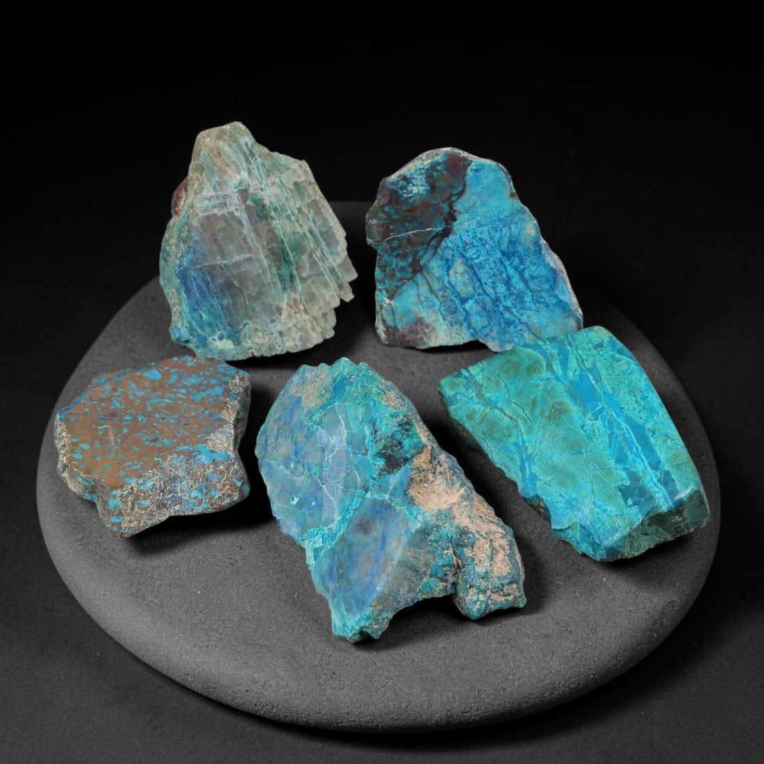 600ct Natural Peruvian Chrysocolla Rough Slice Parcel Lot, 80EX: This rough slice parcel features sawn chrysocolla specimens displaying vibrant turquoise-blue and teal colour zones blended with host quartz matrix. Visible dark mineral veining, natural fracture line