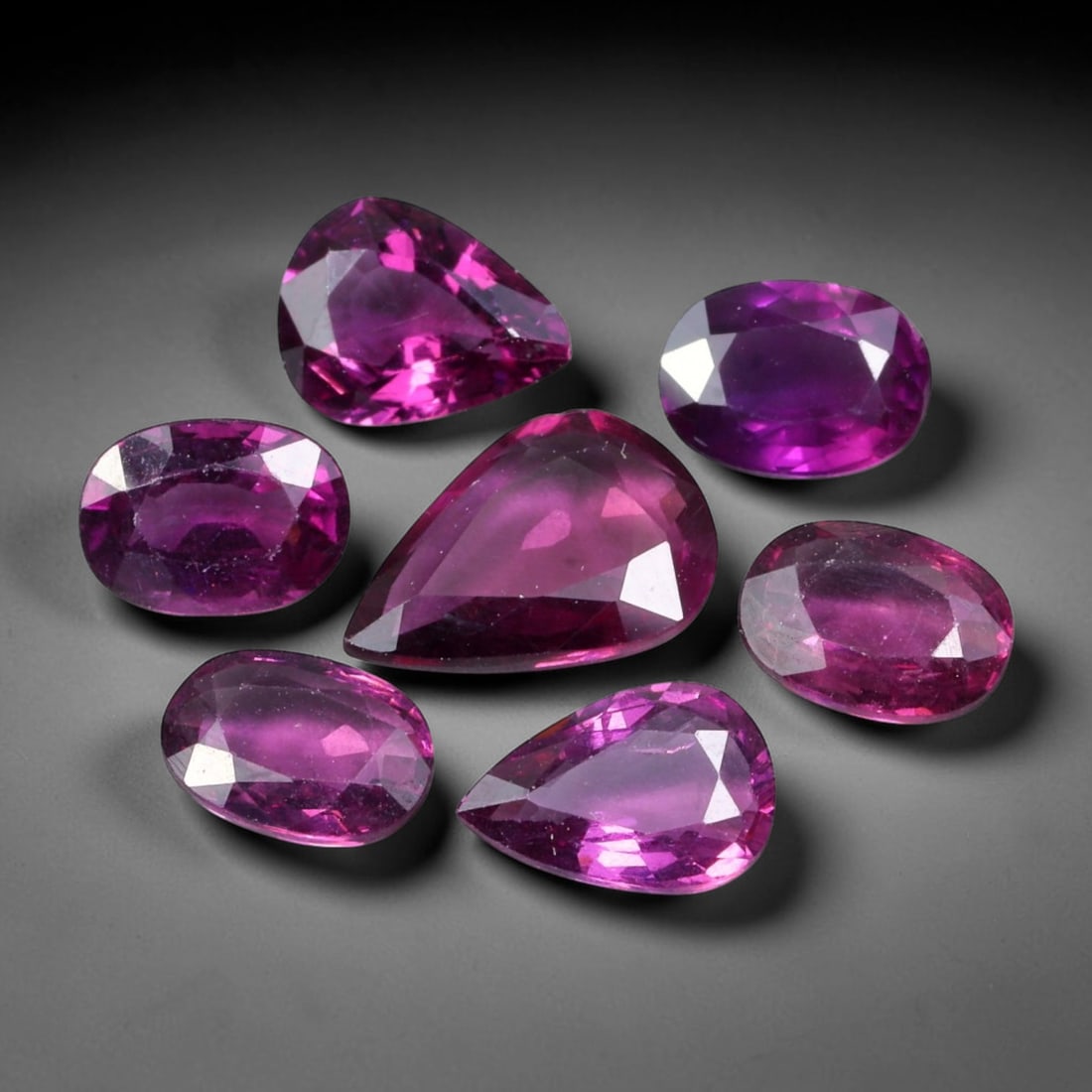 9.06ct Natural Mozambican Rhodolite Garnet Loose Gemstone Parcel Lot, 61EV: This vibrant parcel of rhodolite garnet displays rich saturated magenta-rose tones across a varied assortment of oval, marquise and pear faceted cuts. Precise faceting produces bright sparkle, highlig