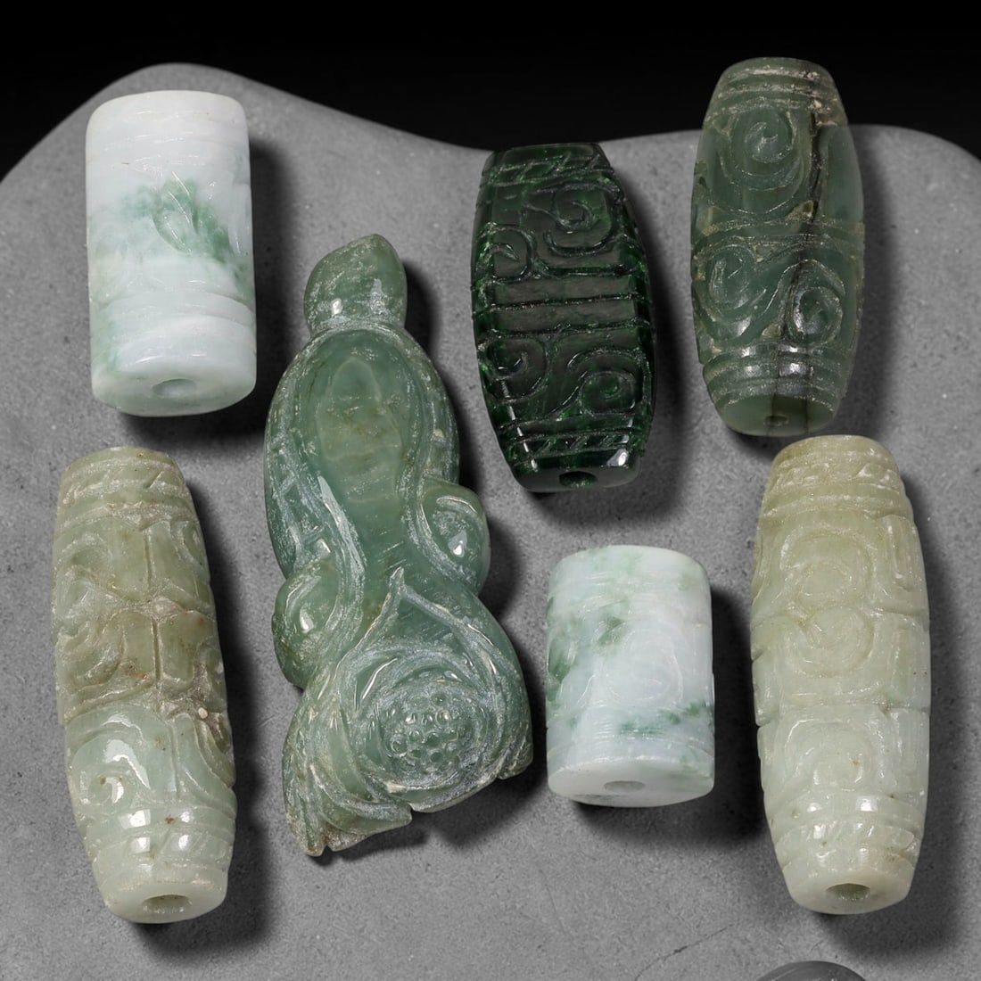 275.60ct Natural Burmese Type A Jadeite Jade Carving Pendant Parcel Lot, 82EX: This parcel lot consists of hand-carved Type A jadeite pendants displaying varied natural colour tones including deep forest green, soft pale green, and warm yellow-gold hues. Each piece finished with