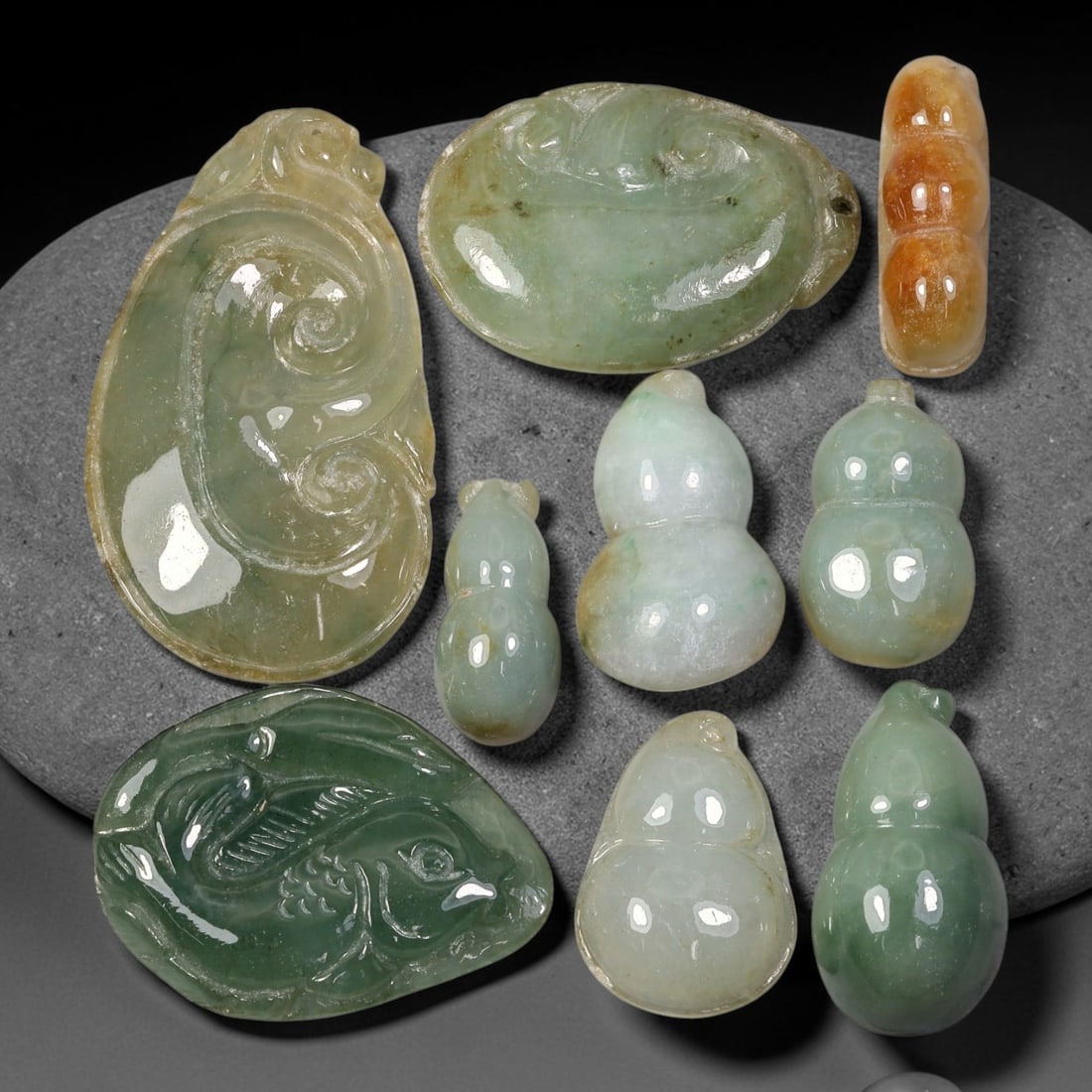 207.80ct Natural Burmese Type A Jadeite Jade Carving Pendant Parcel Lot, 95EX: This parcel lot consists of hand-carved Type A jadeite pendants displaying varied natural colour tones including deep forest green, soft pale green, and warm yellow-gold hues. Each piece finished with
