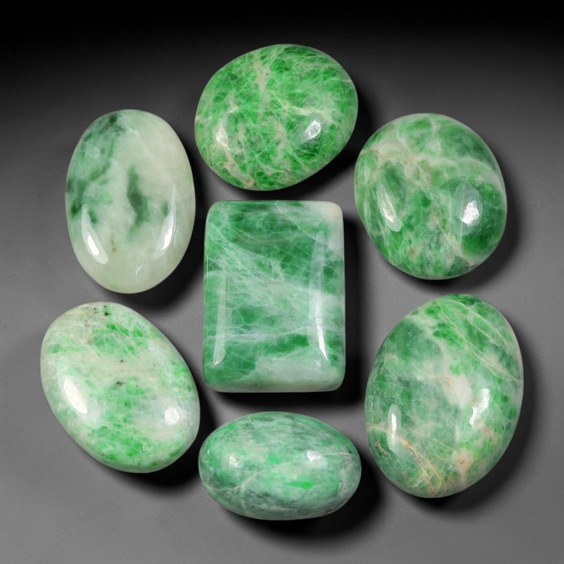 126.35ct Natural Burmese Type A Jadeite Jade Cabochon Parcel Lot, 4BC: This polished oval cabochon parcel displays natural Type A burmese jadeite jade with broad colour variation. High gloss polished domed surfaces reveal natural internal crystalline textures, mineral ve