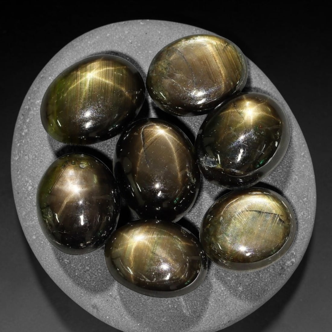 18.66ct Natural Siamese Golden Star Sapphire Cabochon Loose Gemstone Parcel Lot, 77EV: This striking parcel of Siamese golden star sapphire cabochons features deep smoky-golden body tones with sharp well-defined six-rayed asterism across smooth polished oval domed surfaces. Bright metal