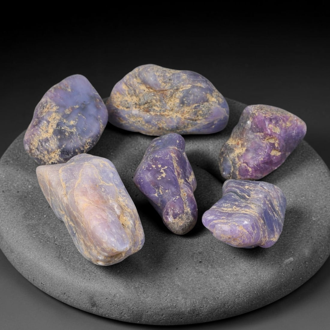 240ct Natural Unheated Sri Lankan Purplish Blue Sapphire Rough Parcel Lot, 54EX: This rough parcel features six naturally water-worn sapphire specimens exhibiting purplish-blue to soft lavender colour tones across the lot. The stones retain natural tumbled outer surfaces with visi