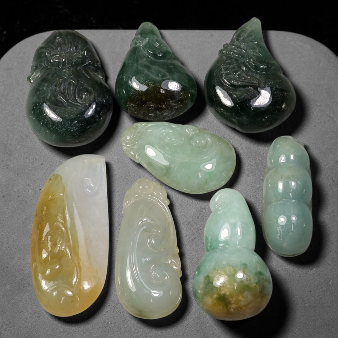 222.62ct Natural Burmese Type A Jadeite Jade Carving Pendant Parcel Lot, 94EX: This parcel lot consists of hand-carved Type A jadeite pendants displaying varied natural colour tones including deep forest green, soft pale green, and warm yellow-gold hues. Each piece finished with