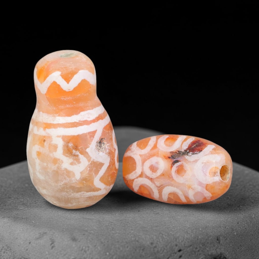 Ancient Sino-Himalayan Region Etched Carnelian Beads Parcel Lot, 22EY: Pair of ancient alkali-etched carnelian beads from the Sino-Himalayan cultural zone, featuring distinct etched surface ornamentation over natural translucent carnelian matrix. Both specimens show auth