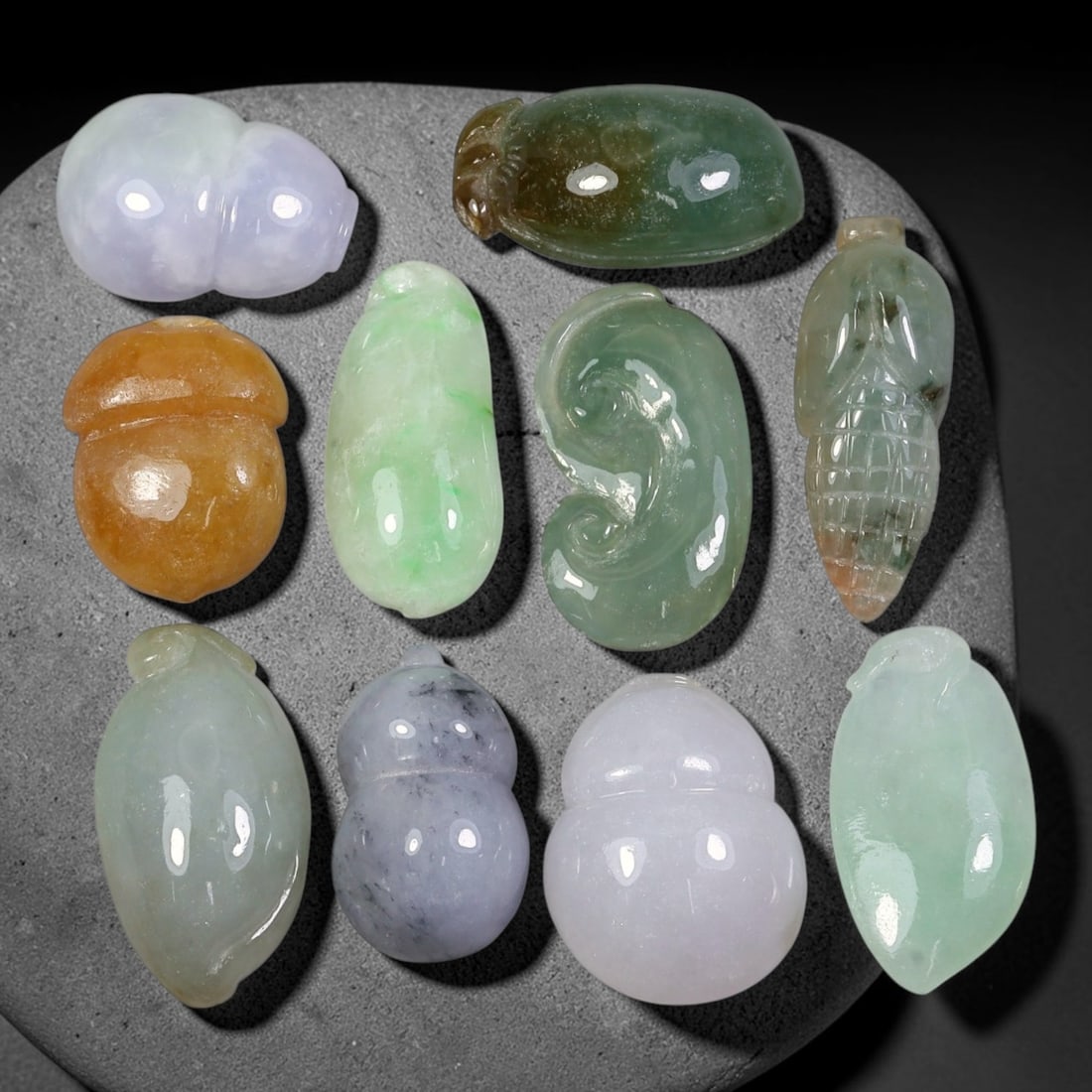 134.72ct Natural Burmese Type A Jadeite Jade Carving Pendant Parcel Lot, 1EY: This parcel lot consists of hand-carved Type A jadeite pendants displaying varied natural colour tones including deep forest green, soft pale green, and warm yellow-gold hues. Each piece finished with