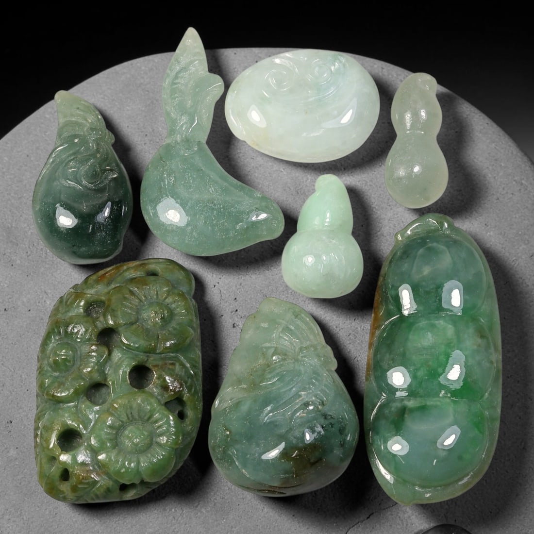 228.46ct Natural Burmese Type A Jadeite Jade Carving Pendant Parcel Lot, 88EX: This parcel lot consists of hand-carved Type A jadeite pendants displaying varied natural colour tones including deep forest green, soft pale green, and warm yellow-gold hues. Each piece finished with