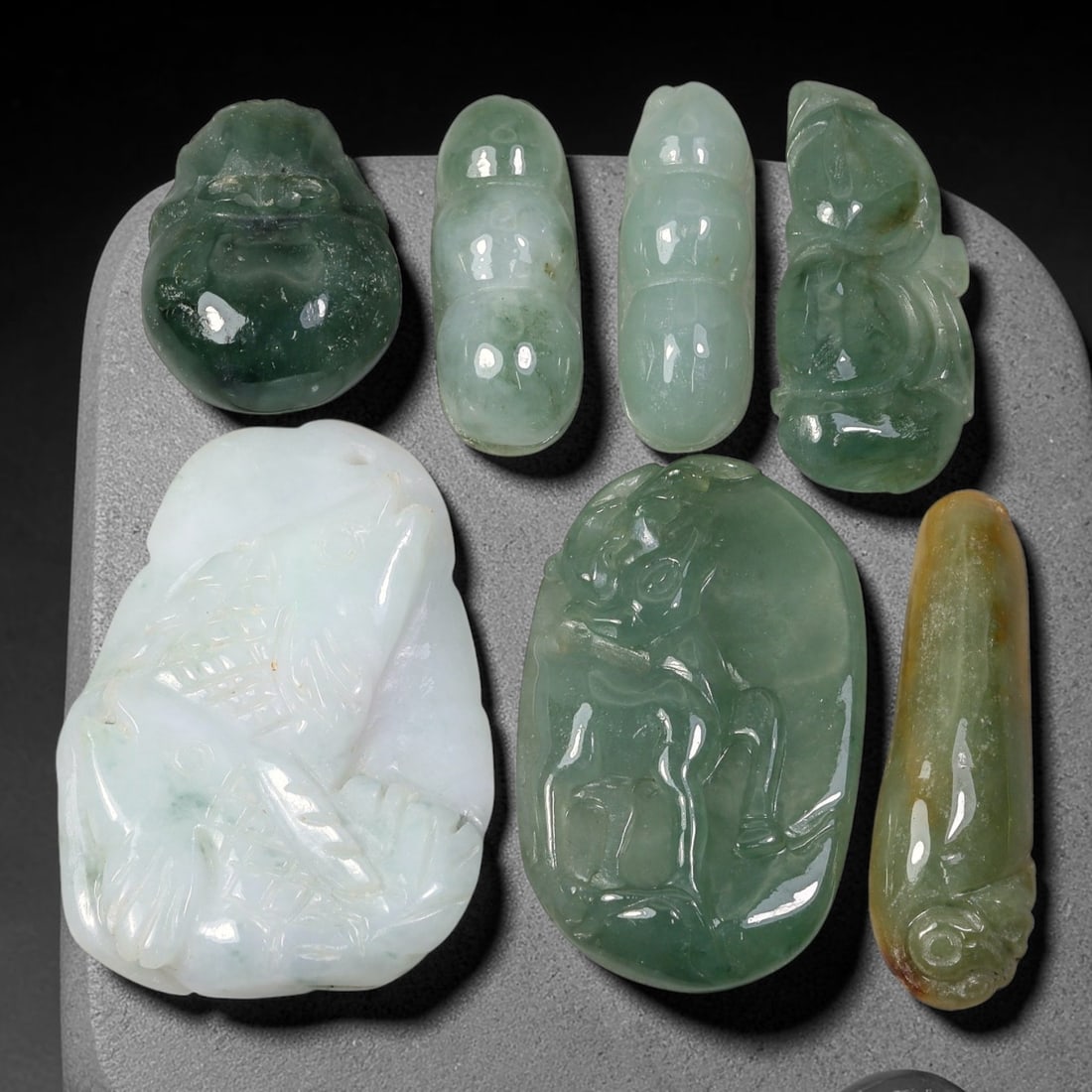 221.19ct Natural Burmese Type A Jadeite Jade Carving Pendant Parcel Lot, 90EX: This parcel lot consists of hand-carved Type A jadeite pendants displaying varied natural colour tones including deep forest green, soft pale green, and warm yellow-gold hues. Each piece finished with