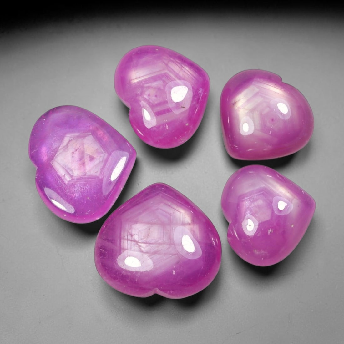 24.84ct Natural Mozambican Ruby Cabochon Loose Gemstone Parcel Lot, 67EV: This distinctive parcel of heart-shaped ruby cabochons displays rich saturated magenta-red colour with visible hexagonal internal growth patterns across smooth polished domed surfaces. Each heart-form