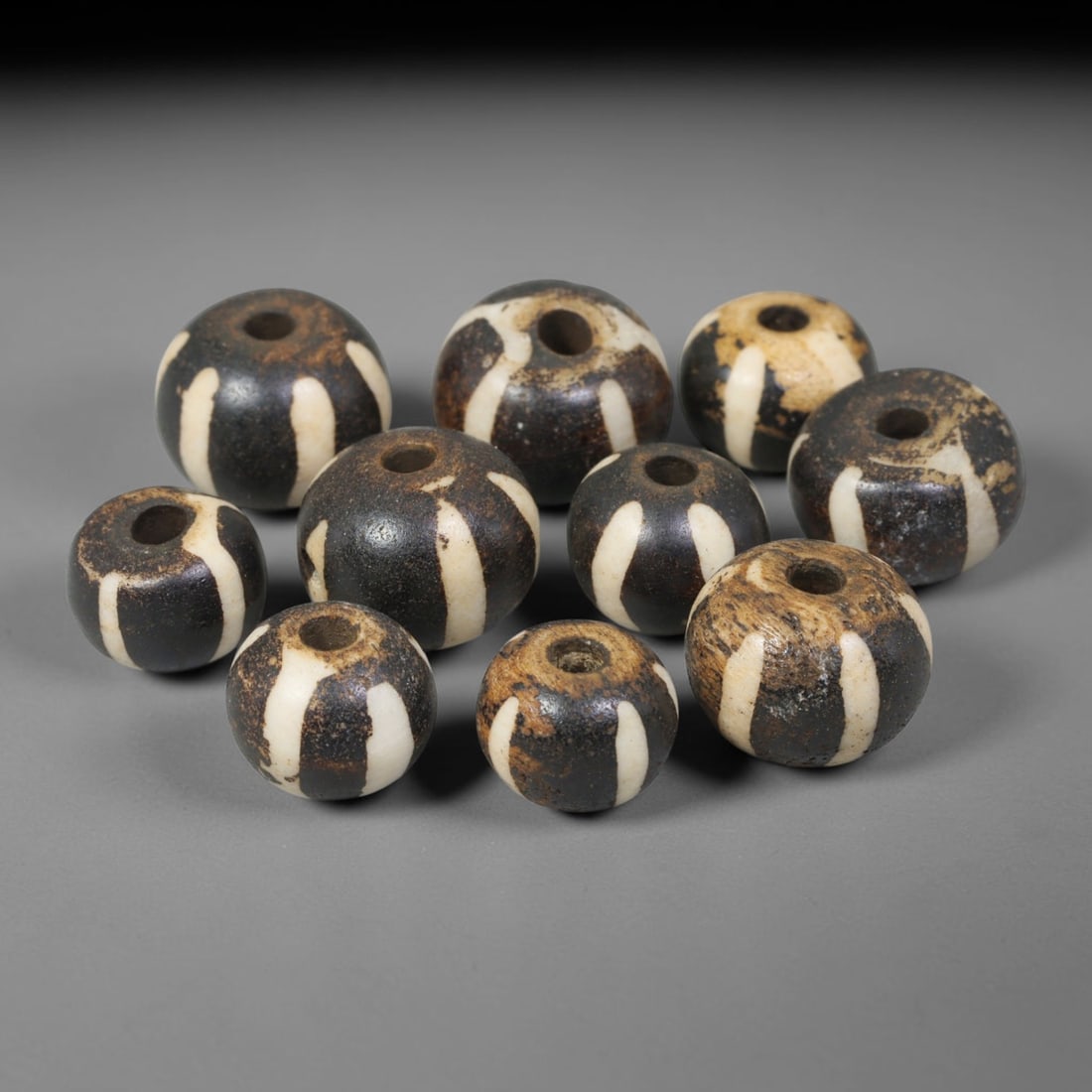 Antique Indo-Himalayan Pumtek Wood Round Striped Etched Beads, 10EV: Fine assembled set of antique Indo-Himalayan pumtek wood round beads decorated with classic vertical etched stripe motifs. The grouping shows natural material variation, deep accumulated patina, and g