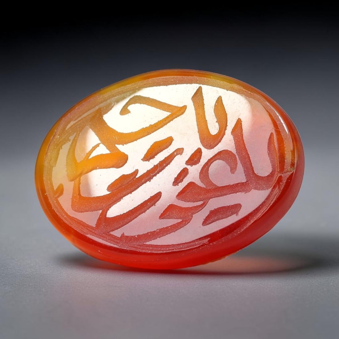 Ancient Medieval Mughal Islamic Carnelian Agate Calligraphic Script Talisman 1526-1857 CE, 43ET: Polished rich-toned carnelian agate cabochon, finely engraved with divided panels of Islamic calligraphic intaglio inscriptions. Deep crisp engraving features segmenting incised lines organizing the s