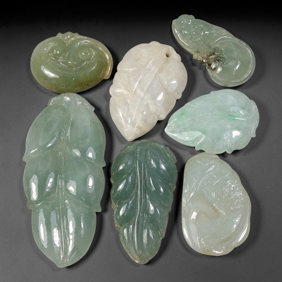 150.23ct Natural Burmese Type A Jadeite Jade Carving Pendant Parcel Lot, 89EX: This parcel lot consists of hand-carved Type A jadeite pendants displaying varied natural colour tones including deep forest green, soft pale green, and warm yellow-gold hues. Each piece finished with