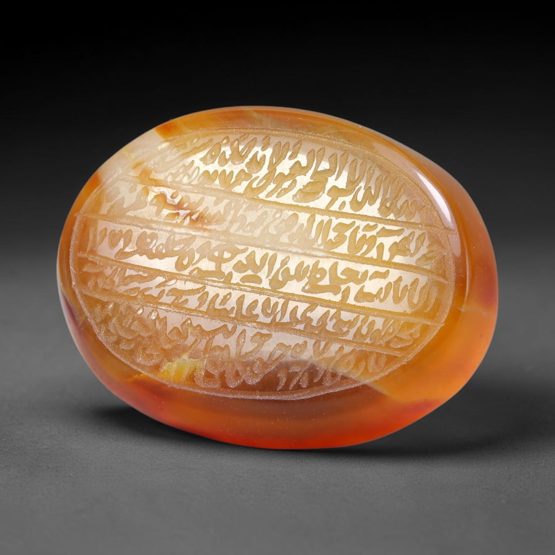 Ancient Medieval Mughal Islamic Carnelian Agate Calligraphic Script Talisman 1526-1857 CE, 98ES: Polished rich-toned carnelian agate cabochon, finely engraved with divided panels of Islamic calligraphic intaglio inscriptions. Deep crisp engraving features segmenting incised lines organizing the s