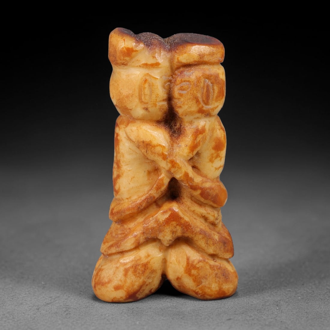 Ancient Primitive Carved Bone Embracing Twin Human Figurine Amulet, 66AB: Miniature hand-carved pale bone talisman depicting two intertwined human figures locked in an embracing pose, a symbol of unity, companionship and protective bonding. Natural amber-brown aged patina m