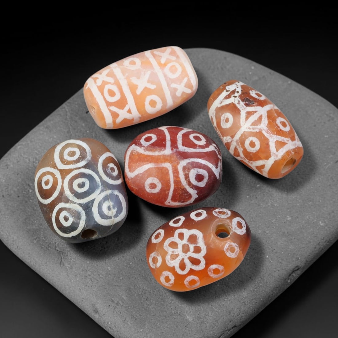Ancient Sino-Himalayan Region Etched Carnelian Beads Parcel Lot, 5EY: Group of ancient etched carnelian beads originating from the Sino-Himalayan cultural sphere, displaying classic alkali-etch decorative motifs across translucent carnelian bodies. Each bead exhibits hi