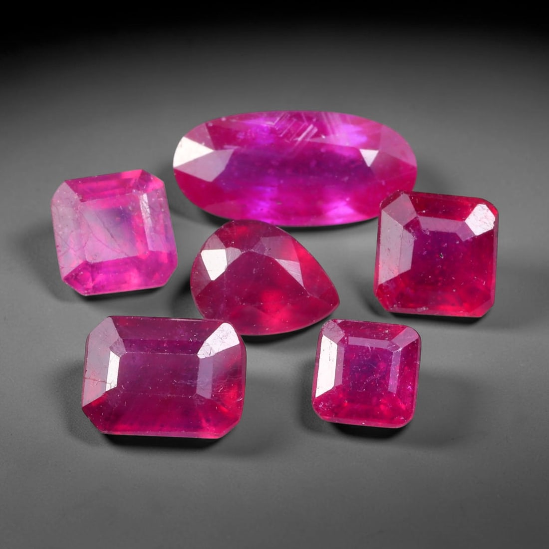 10.92ct Natural Mozambican Ruby Faceted Parcel Lot, 40EW: This faceted gemstone lot features multiple mixed-shape cut rubies displaying rich saturated crimson to vivid pink-red colour tones across oval, heart and square modified faceted forms. Each stone is 