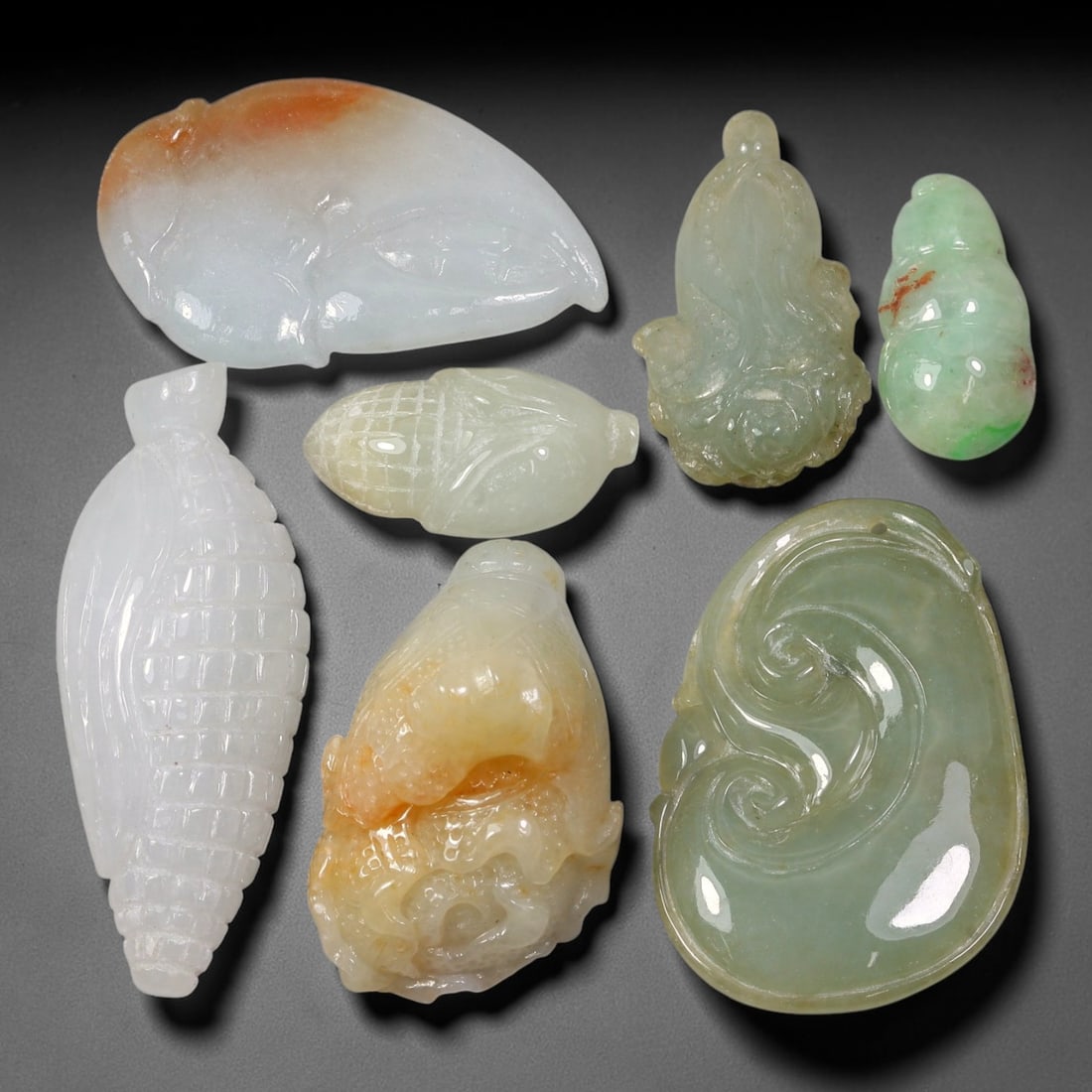242ct Natural Burmese Type A Jadeite Jade Carving Pendant Parcel Lot, 85EX: This parcel lot consists of hand-carved Type A jadeite pendants displaying varied natural colour tones including deep forest green, soft pale green, and warm yellow-gold hues. Each piece finished with