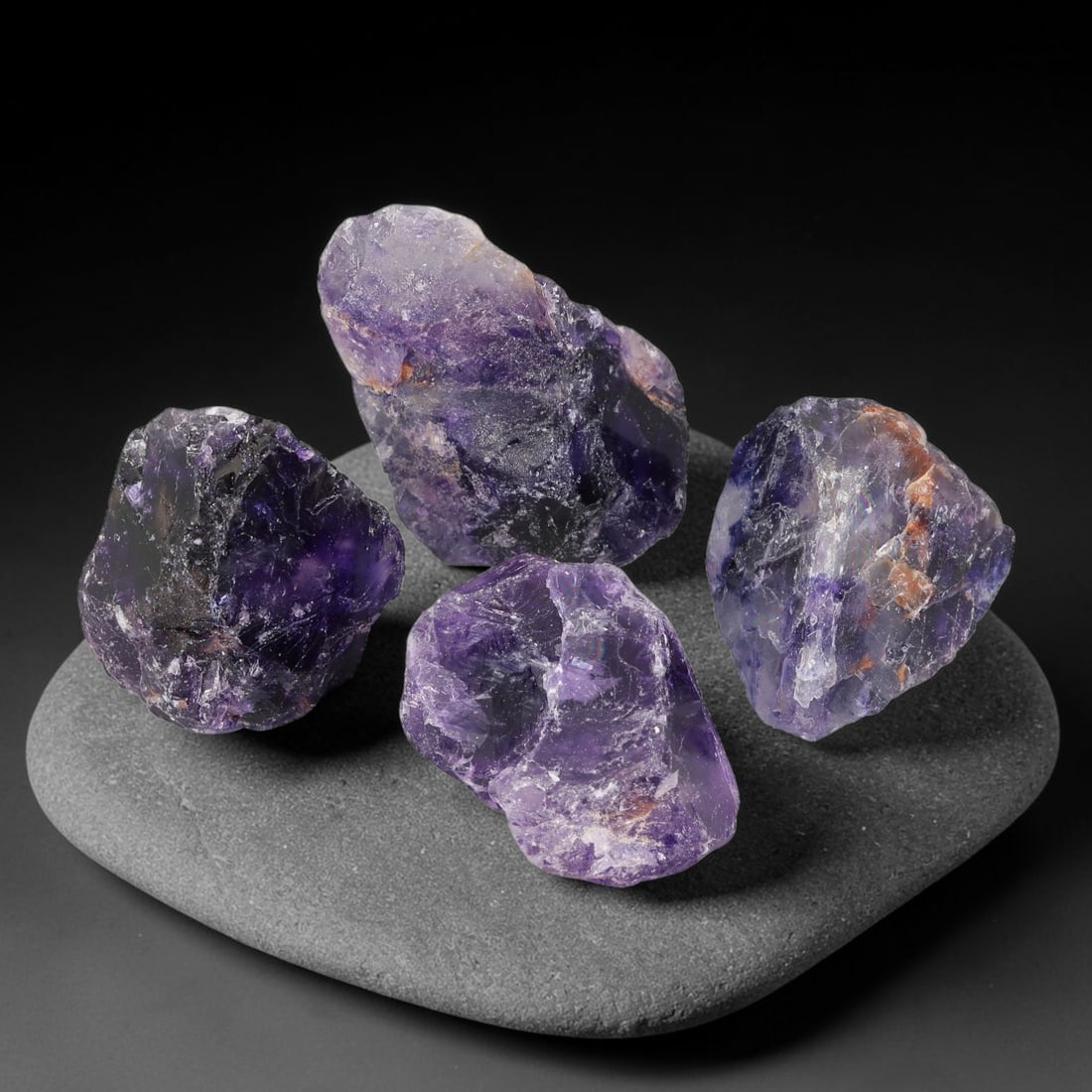 585ct Natural Chinese Purple Fluorite Rough Parcel Lot, 73EX: This rough parcel consists of unpolished fluorite chunks displaying rich deep violet to soft lavender purple colour gradients. The raw specimens show irregular fractured crystal surfaces, with patches