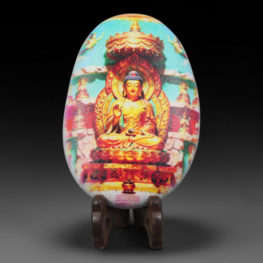 A Tibetan Thangka Style Painted River Stone with a Buddhist Figure, 67BC: Painted on a naturally rounded river stone, the work depicts a seated Shakyamuni Buddha in a thangka-style composition. The figure is shown in a meditative posture upon a lotus throne, with an ornate 