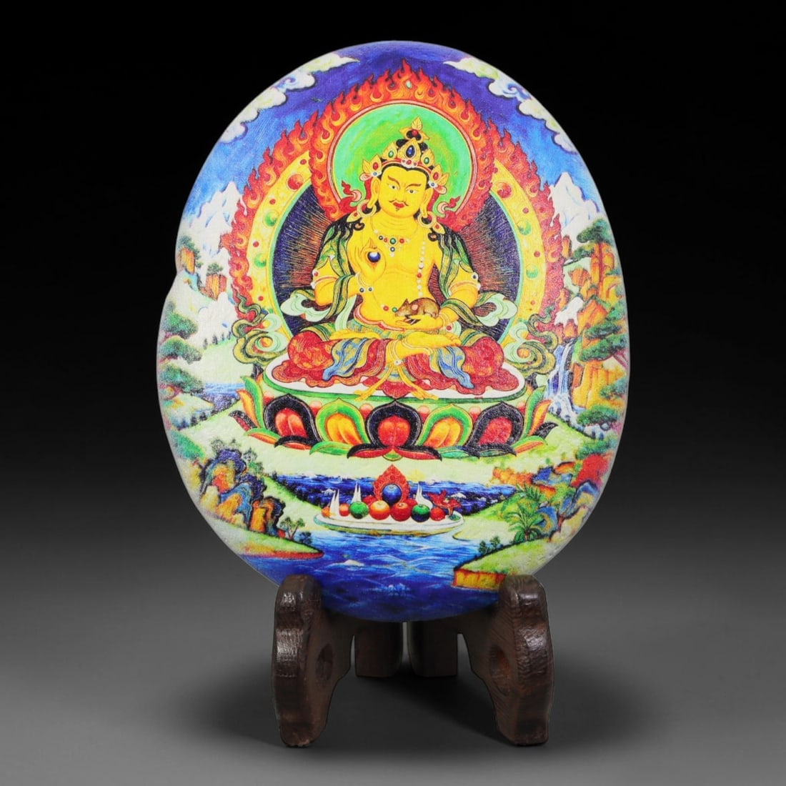 A Tibetan Thangka Style Painted River Stone with a Wealth Deity, 78BC: Painted on a naturally rounded river stone, the work depicts Yellow Jambhala, a wealth deity, in a thangka-style composition. The figure is shown seated in a meditative posture upon a lotus throne, su