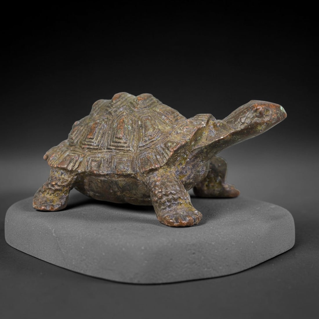 A Chinese Bronze Tortoise Figurine Effigy, 21AD: Cast in bronze, this naturalistic tortoise sculpture is modelled in a walking pose with outstretched neck. Fine detailed relief rendering defines the segmented geometric shell patterns, textured scaly