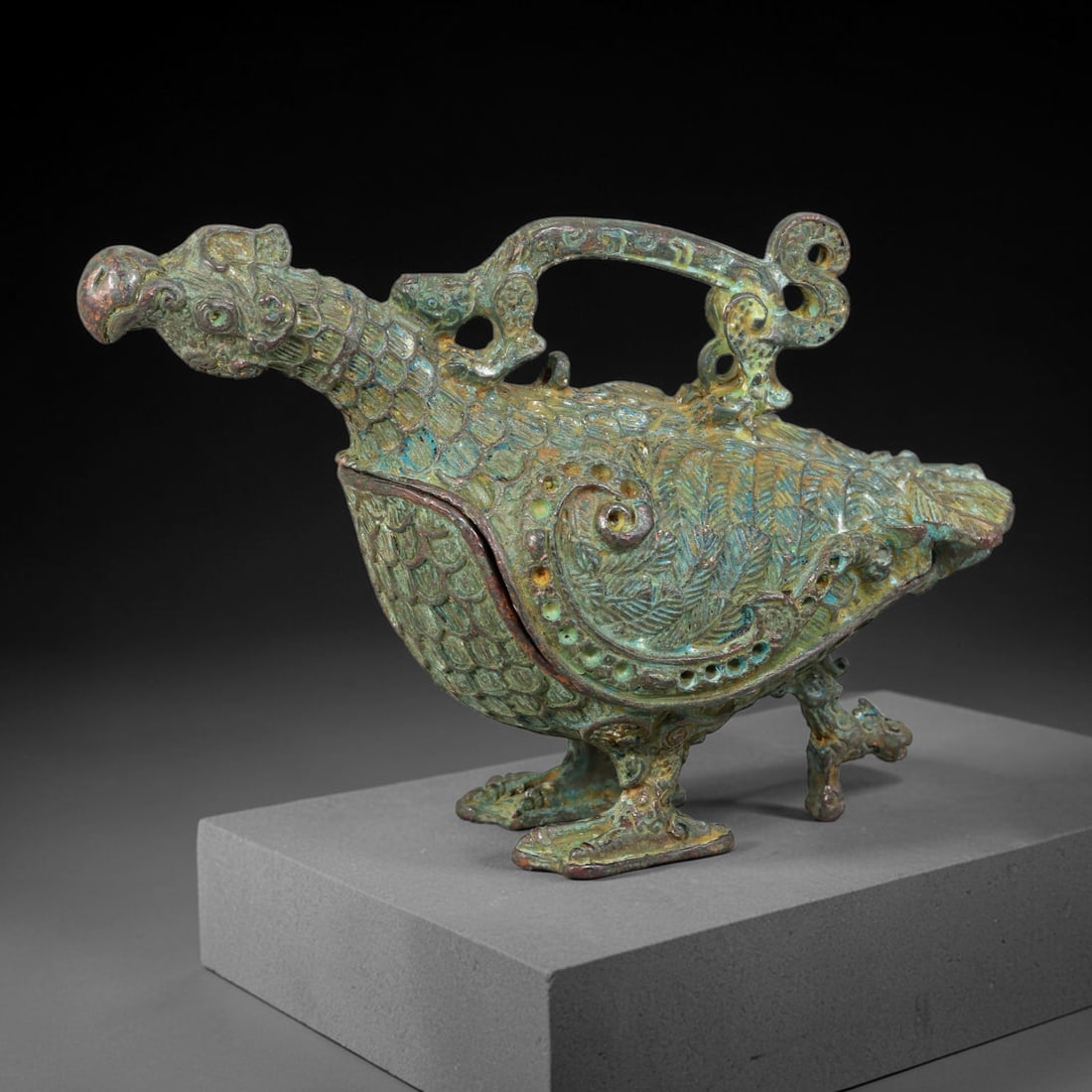 A Chinese Bronze Phoenix-Form Lidded Censer, 70AD: Cast in bronze, this figural censer is modelled as a detailed phoenix bird standing upon ornate clawed feet. Its surface is richly decorated with fine scaled plumage, scrolling wing motifs and elabora