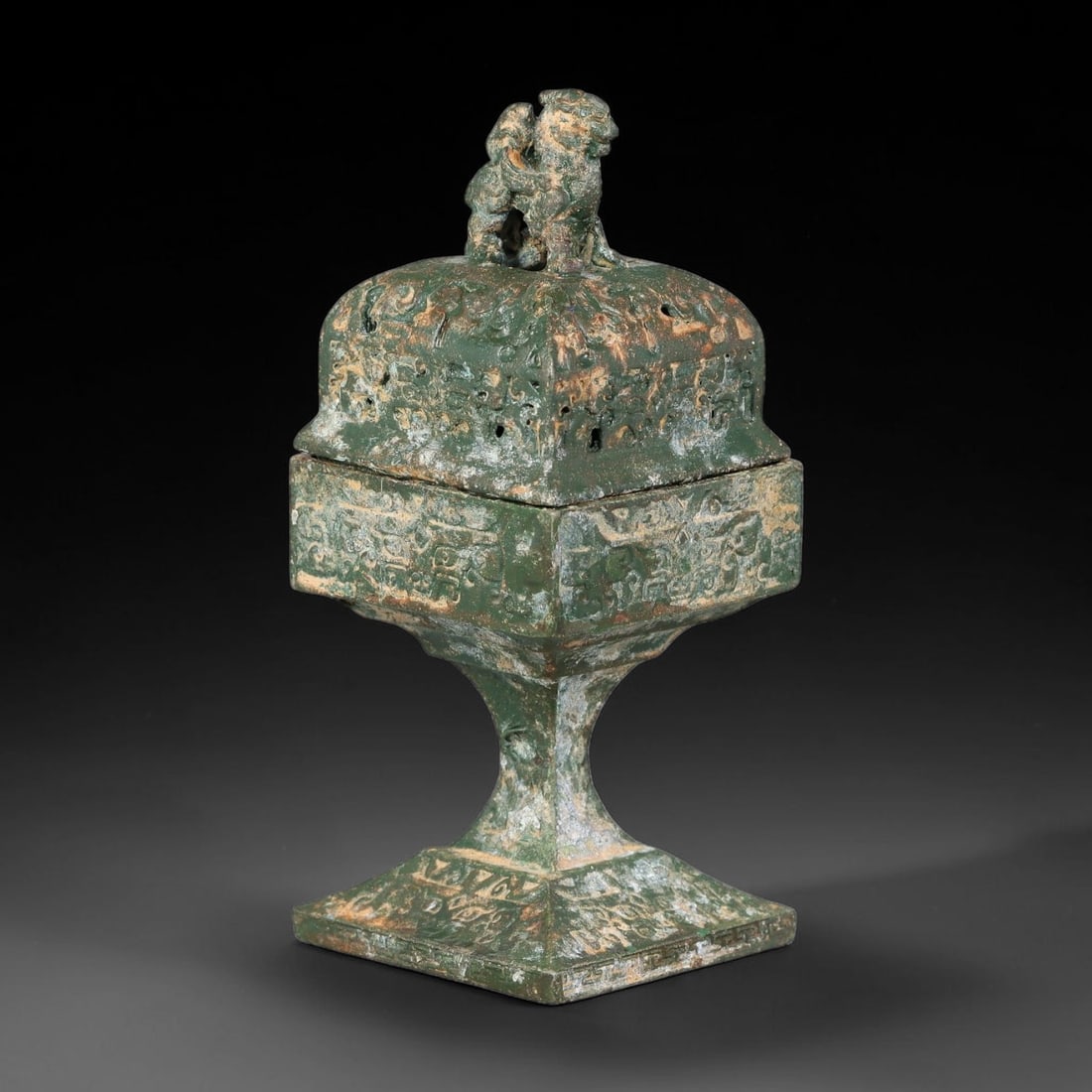 A Chinese Square Stem-Foot Bronze Censer with Lion Finial, 84AD: Cast bronze stem-foot censer of square section, standing on a broad square base supported by a flared hollow stem. The detachable pierced lid is surmounted by a seated lion-form finial and features op