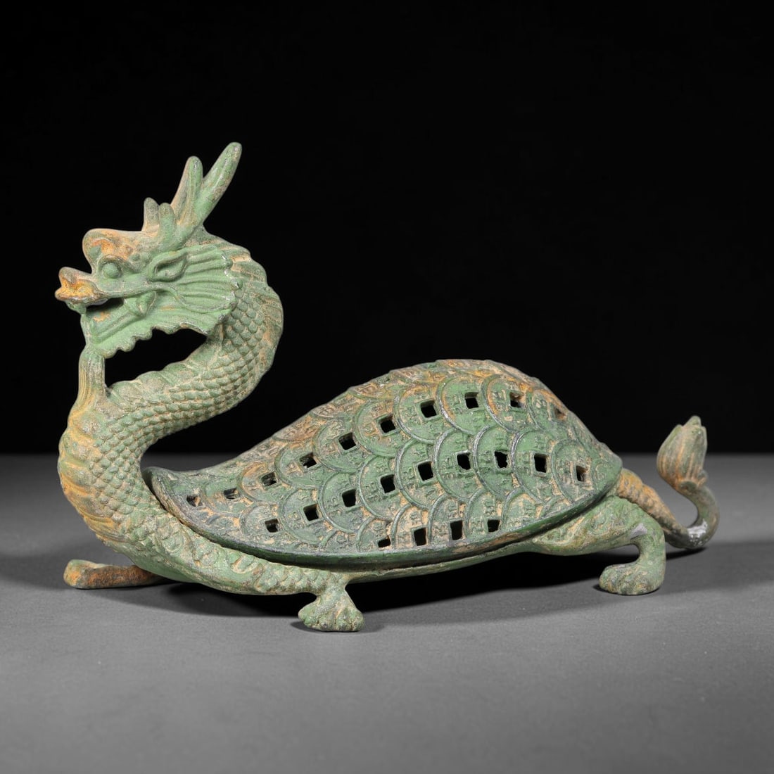 A Chinese Bronze Dragon-Tortoise Reticulated Censer, 71AD: Cast bronze censer modelled as a mythical dragon-tortoise beast with raised dragon head, scaled neck and four supporting limbs. The domed shell lid is finely pierced with repeating coin-shape open-wor