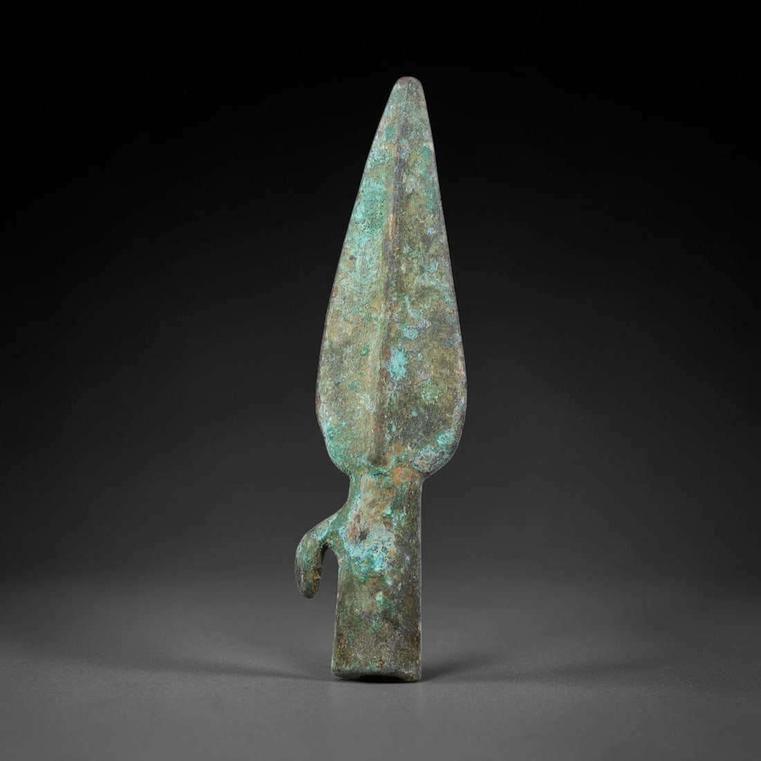 Ancient Chinese Warring-States Period Bronze Spear Point (475-221 BCE), 4AJ: Authentic ancient bronze spear tip of Warring-States manufacture, with tapering pointed blade defined by raised central strengthening rib, complete socket tang fitted with a curved side hook for lashi