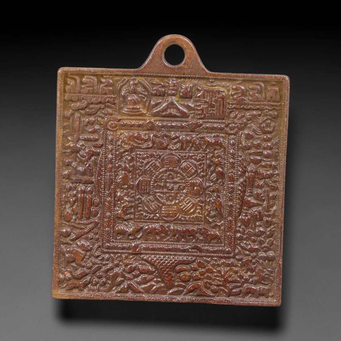 A Tibetan Bronze Square Protective Amulet Plaque, 51AD: Cast bronze square protective amulet plaque fitted with integral pierced suspension loop at upper edge. The face is densely covered in multi-layer high-relief iconography featuring astrological diagra