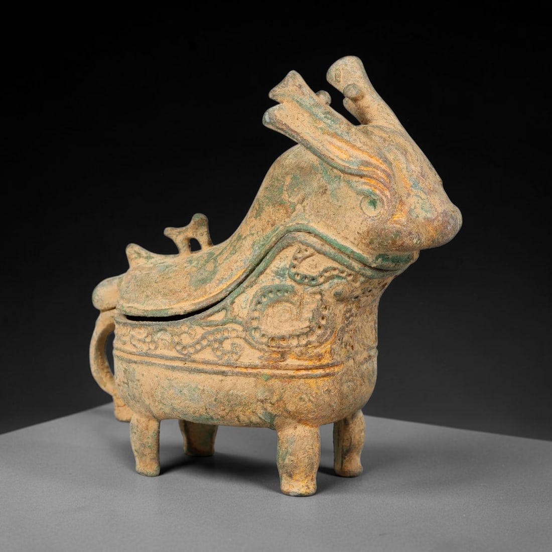 A Chinese Archaic-Style Bronze Zoomorphic Ritual Vessel Gong, 58AD: Cast bronze ritual gong vessel modelled in the form of a horned mythical beast, complete with hinged removable lid, looping rear handle and four sturdy short legs. The exterior is decorated with raise