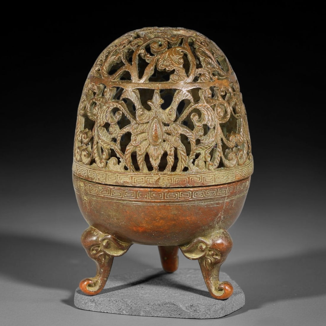 A Chinese Bronze Tripod Censer with Egg-Shaped Open-Work Floral Dome, 97AD: Cast bronze tripod censer with bulbous lower body supported by three elephant-head cabriole legs. The upper domed section is fully pierced with elaborate open-work scrolling floral and foliate pattern