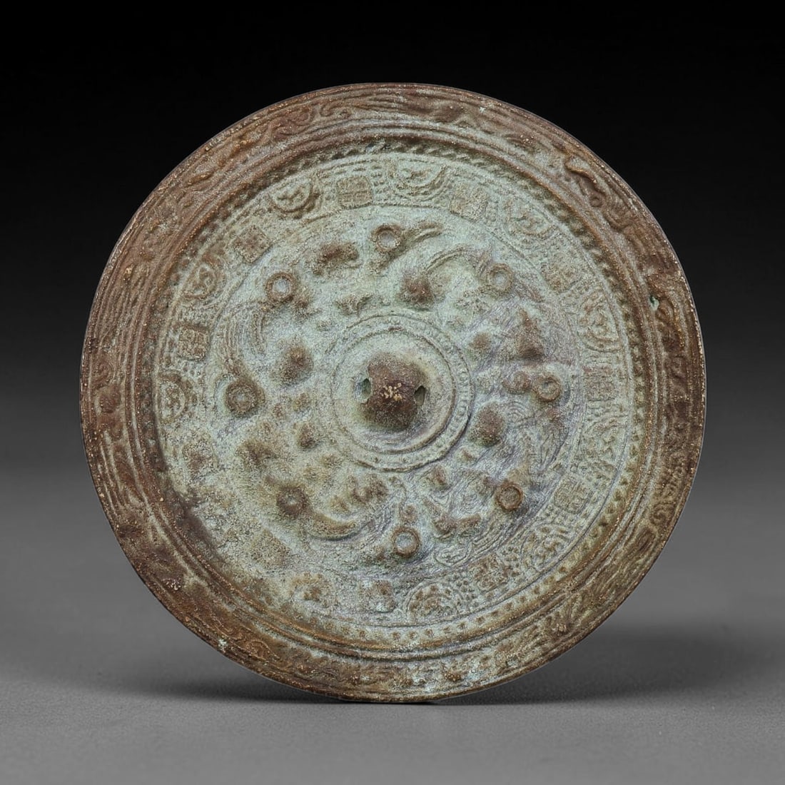 A Chinese Archaic-Style Bronze Circular Mirror with Mythical Beasts and Inscription Bands, 26AJ (1 of 2)