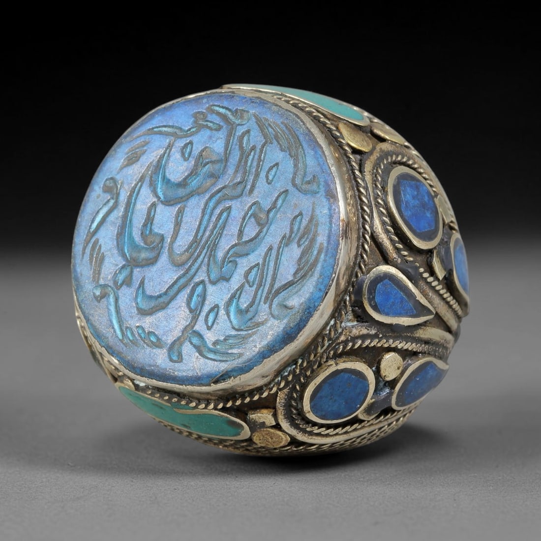 Vintage Islamic Handcrafted Silver Plated Calligraphic Talisman Statement Ring, 35AJ: This vintage hand-wrought Islamic statement ring features a central engraved panel bearing traditional calligraphic detailing, set within an ornate silver-plated metal band. The mounting is enriched w