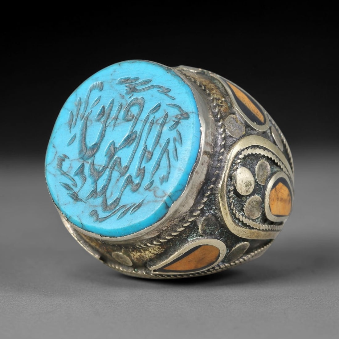 Vintage Islamic Handcrafted Silver Plated Calligraphic Talisman Statement Ring, 44AJ: This vintage hand-wrought Islamic statement ring features a central engraved panel bearing traditional calligraphic detailing, set within an ornate silver-plated metal band. The mounting is enriched w
